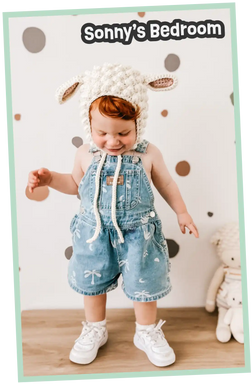Toddler in a sheep hat and denim overalls