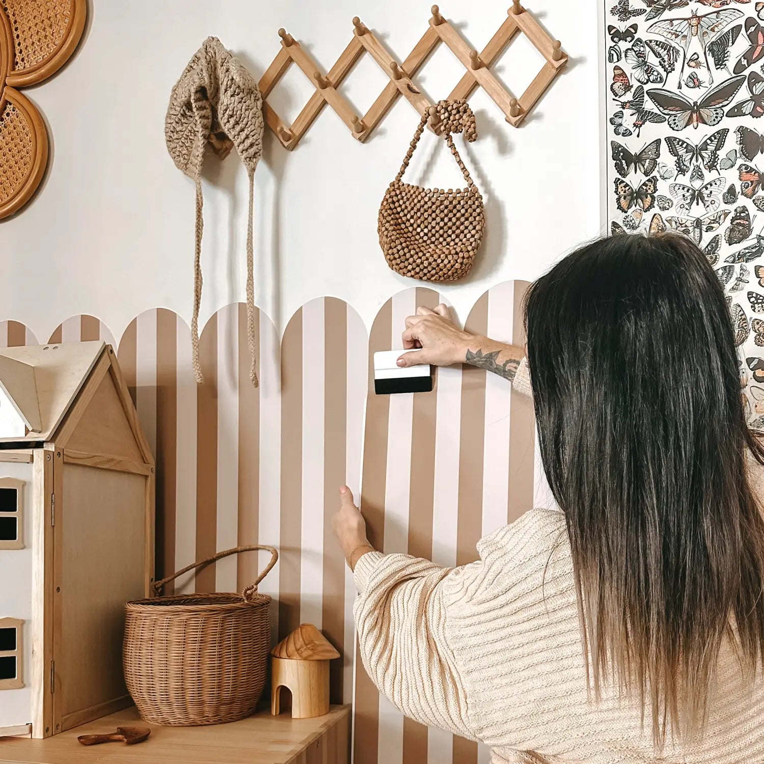 Person applying striped wall decals in neutral nursery