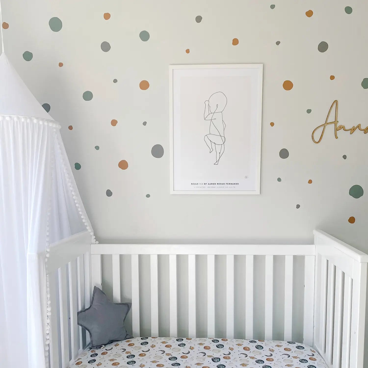Nursery with polka dot wall decals in sage and terracotta tones