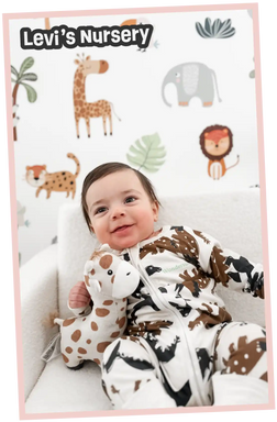 Smiling baby in a giraffe-print onesie holding a plush giraffe toy.