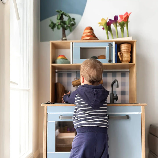 Child playing with a toy kitchen.